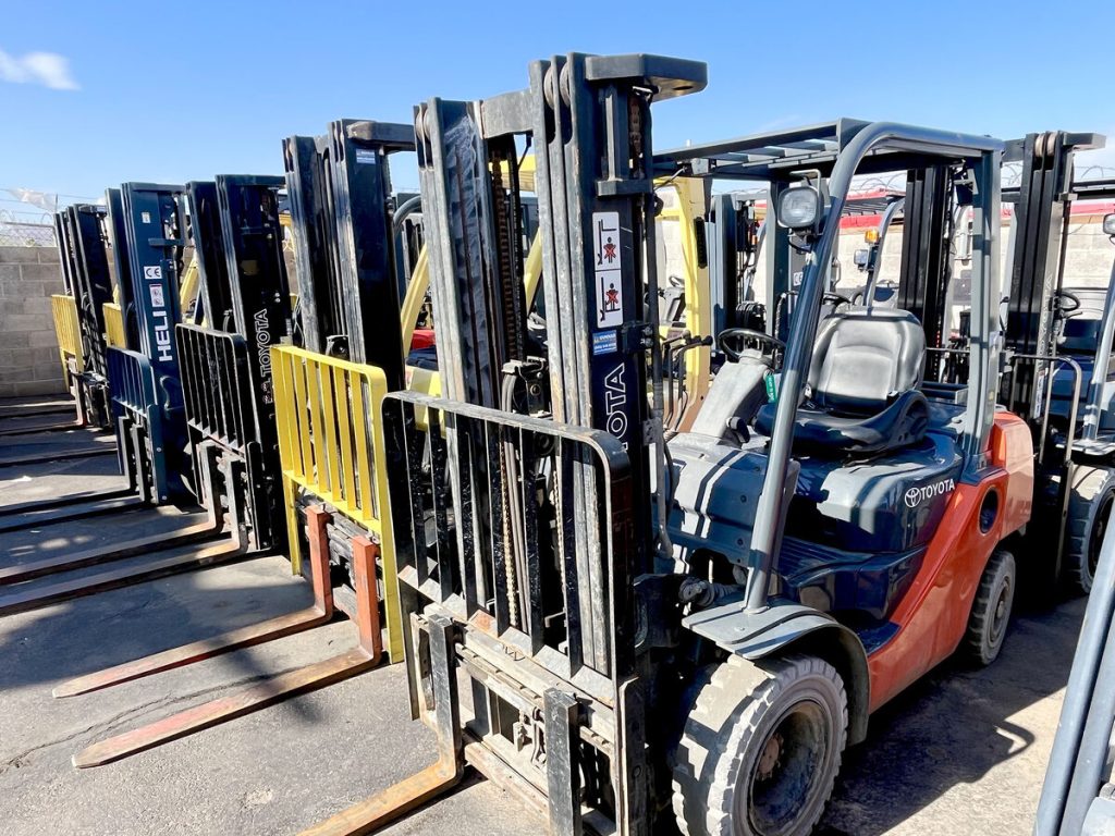 Row of used Heli and Toyota forklifts for sale on the Gunnar Forklift Sales lot